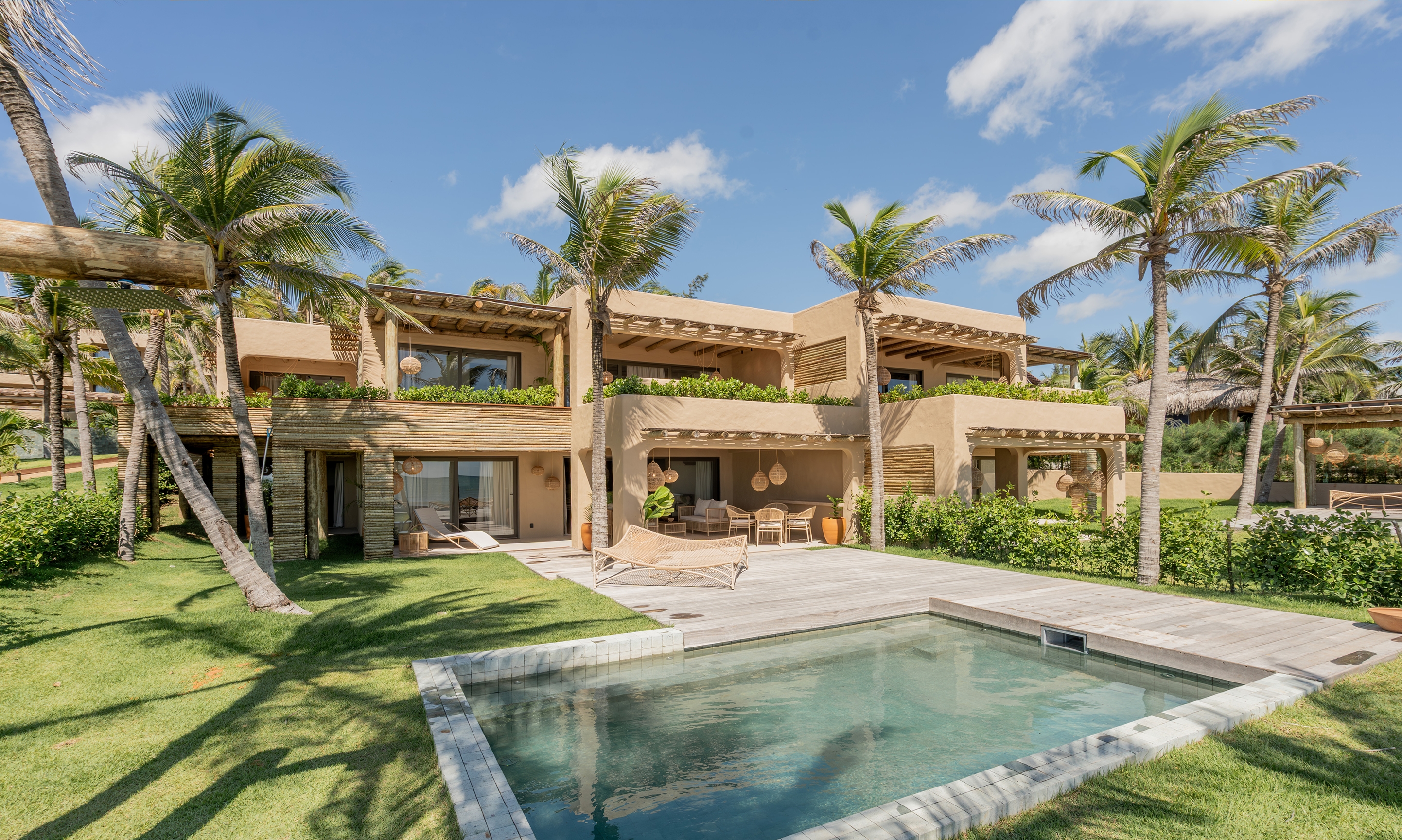 Aqua de Mar with a pool and palm trees in the background